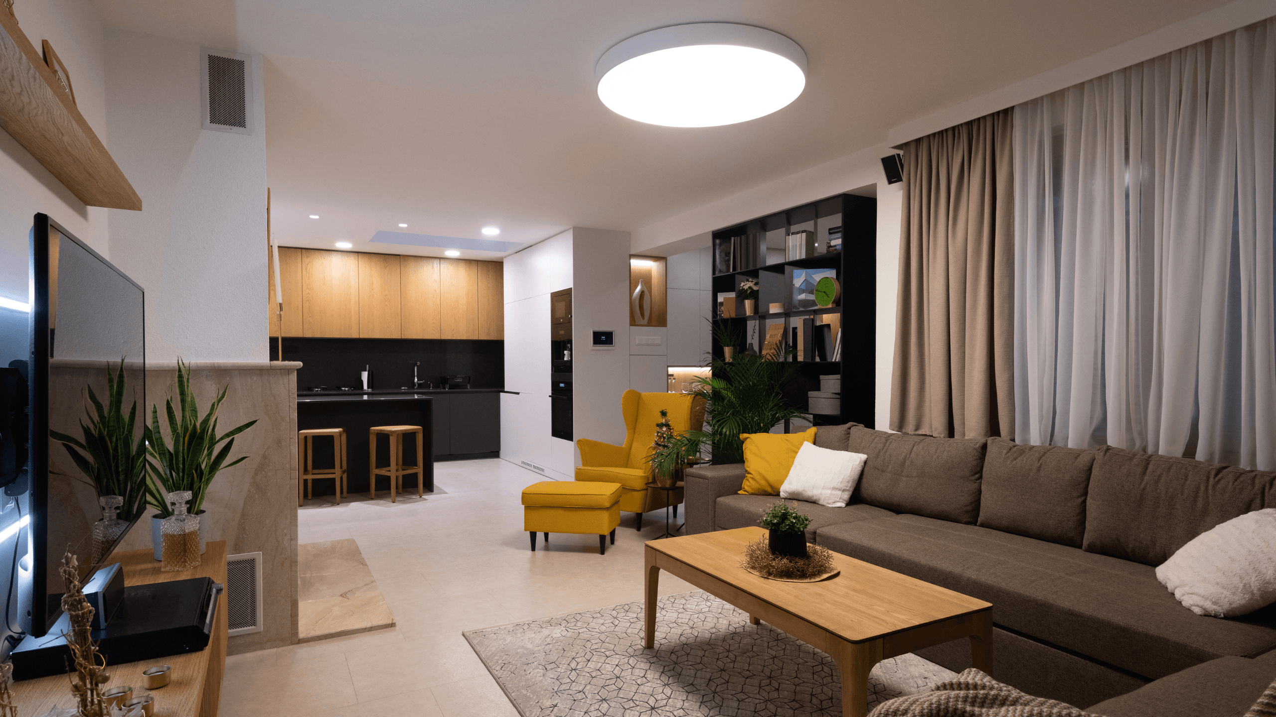 Sala Aconchegante com Cores Neutras, Toques de Cor e Cozinha Planejada ao Fundo